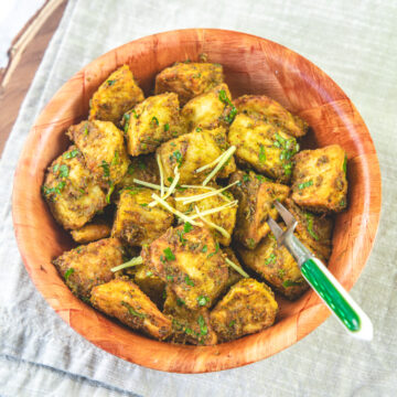 A bowl of aloo chaat garnished with julienned ginger.