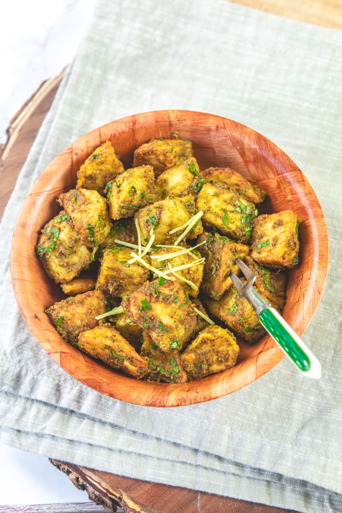 A bowl of aloo chaat garnished with julienned ginger.