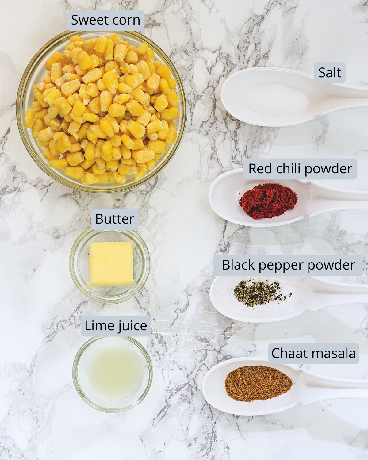 Masala corn ingredients in bowls and spoons with labels.