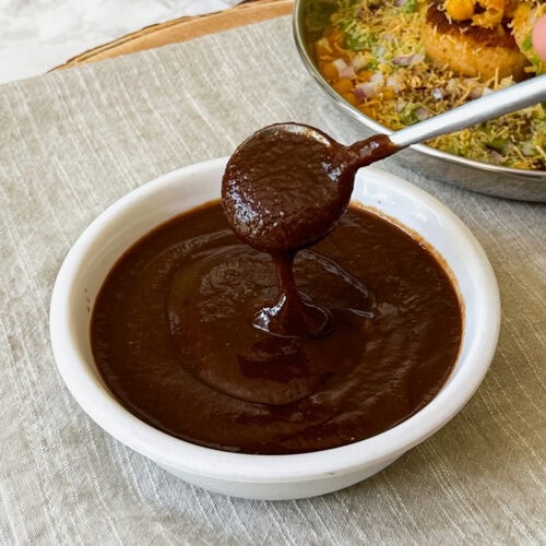 Drizzling tamarind date chutney back in a bowl.