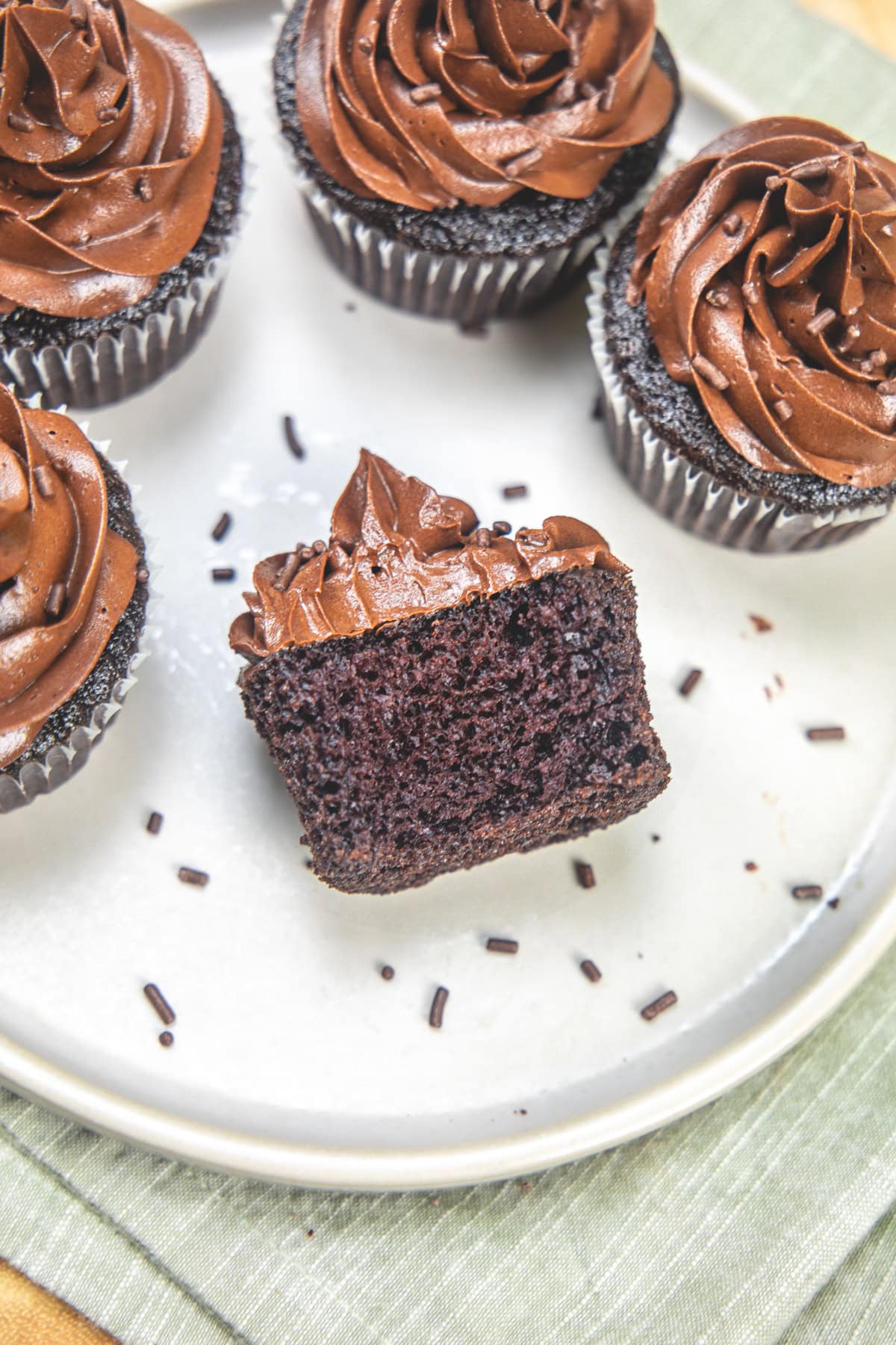 One eggless chocolate cupcake cut into half to show inside texture.