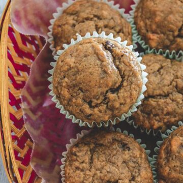 eggless banana muffins in a basket with parchment paper liner