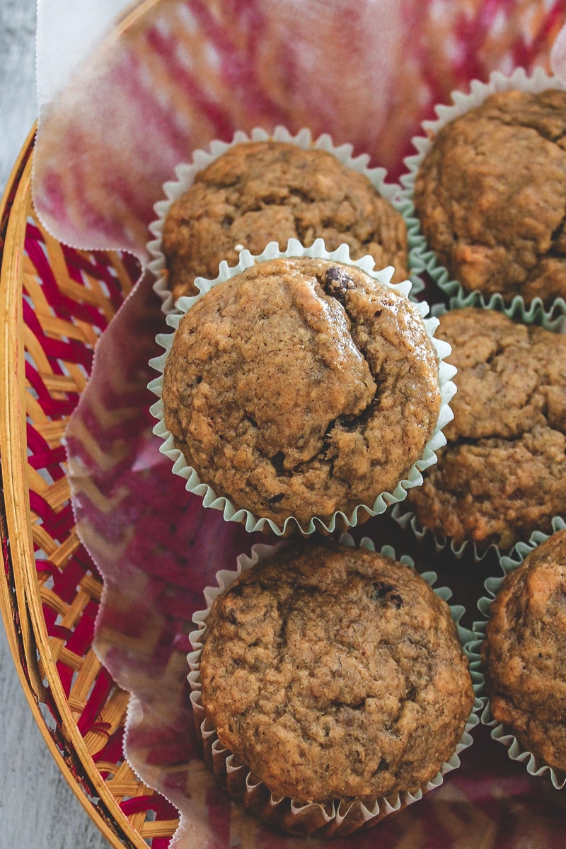 Eggless banana muffins in a basket with parchment paper liner