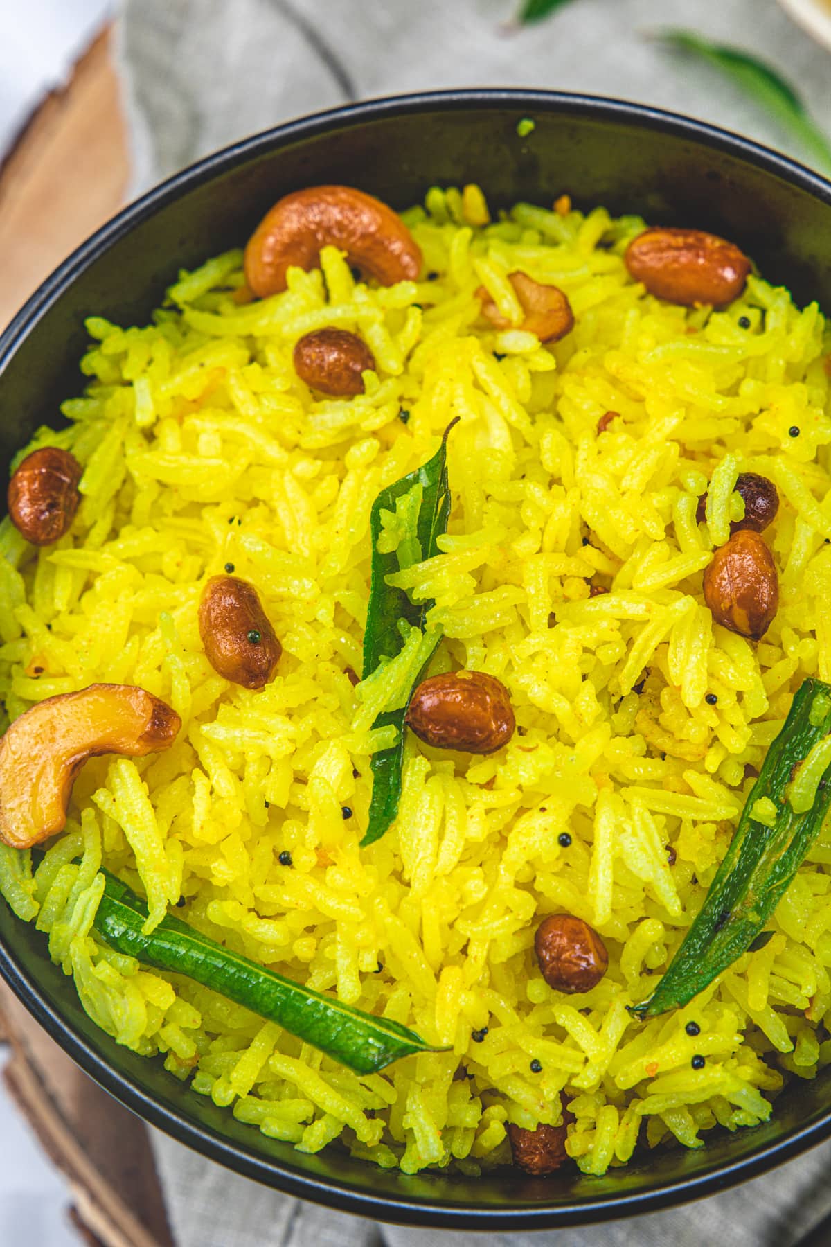 Lemon rice in a black bowl.