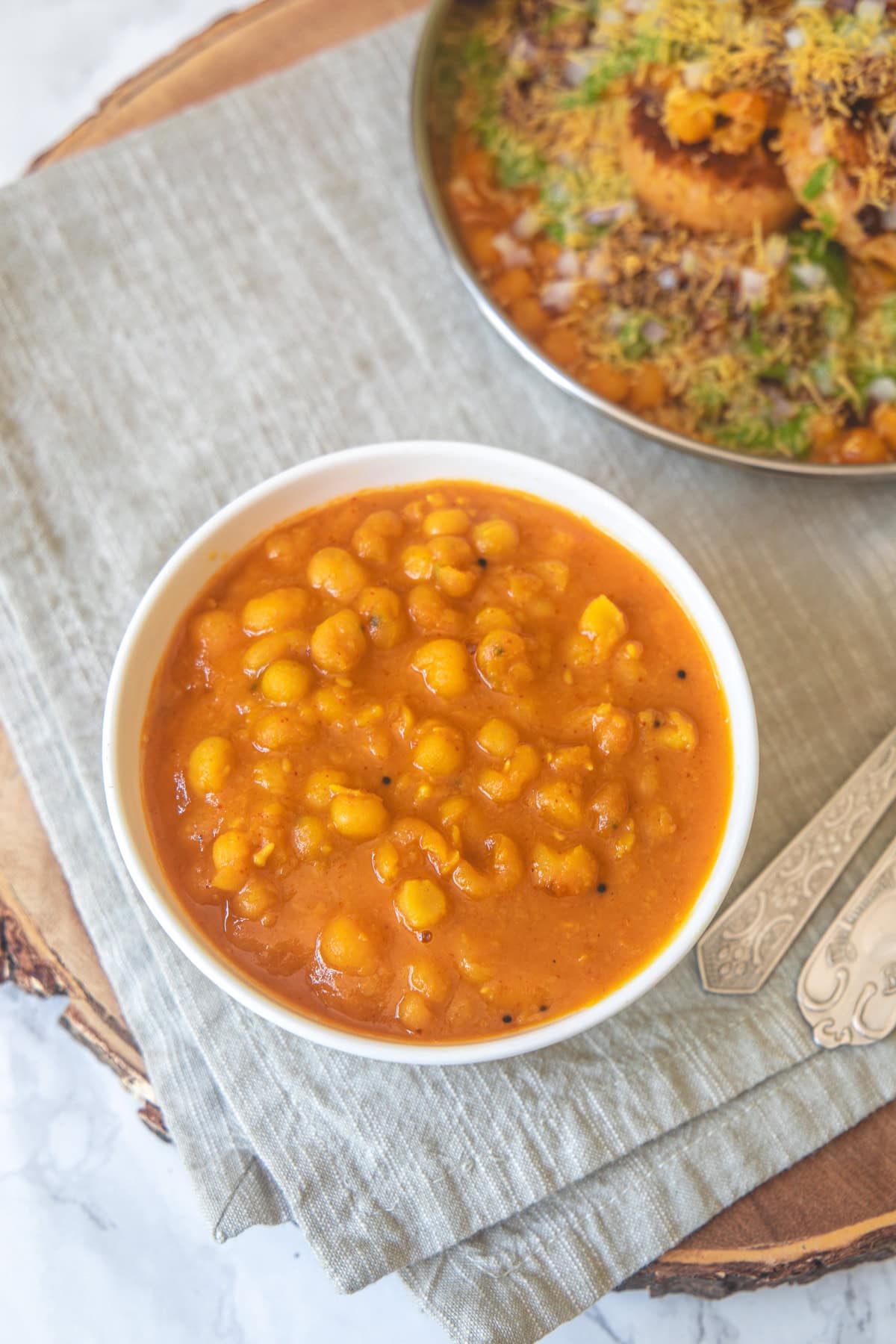 Instant pot ragda in a bowl with ragda pattice plate in the back.