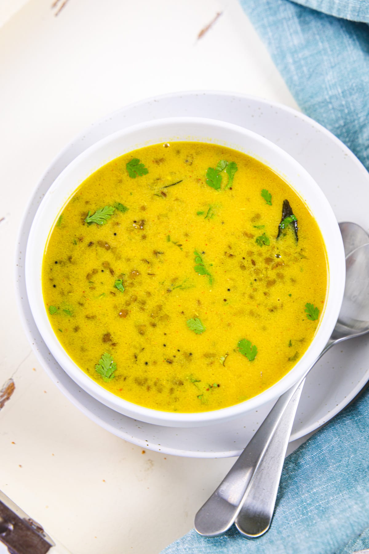 A bowl of khatta moong with spoon on the side.