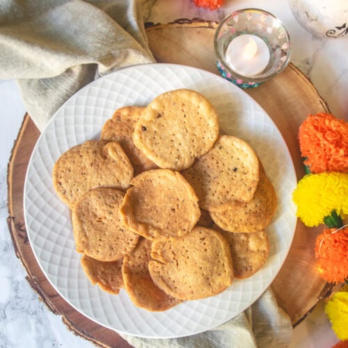 Farsi puri in a plate with diwali diya and garland in the back.