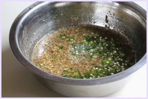 Water, oil and spices mixed in a bowl for mathi gota batter.