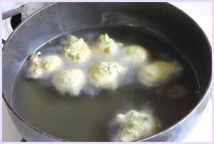 Frying methi na gota in hot oil.