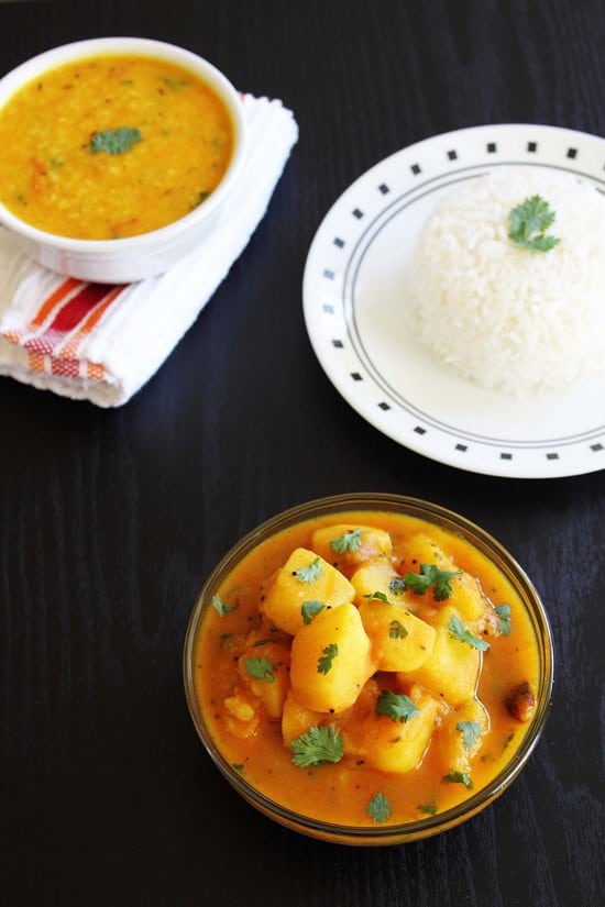 Rasawala batata nu shaak in a bowl served with rice and dal.