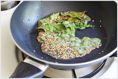 Adding tadka ingredients.