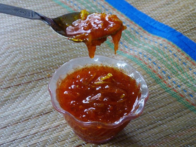 taking a spoonful of mango chunda from the bowl.