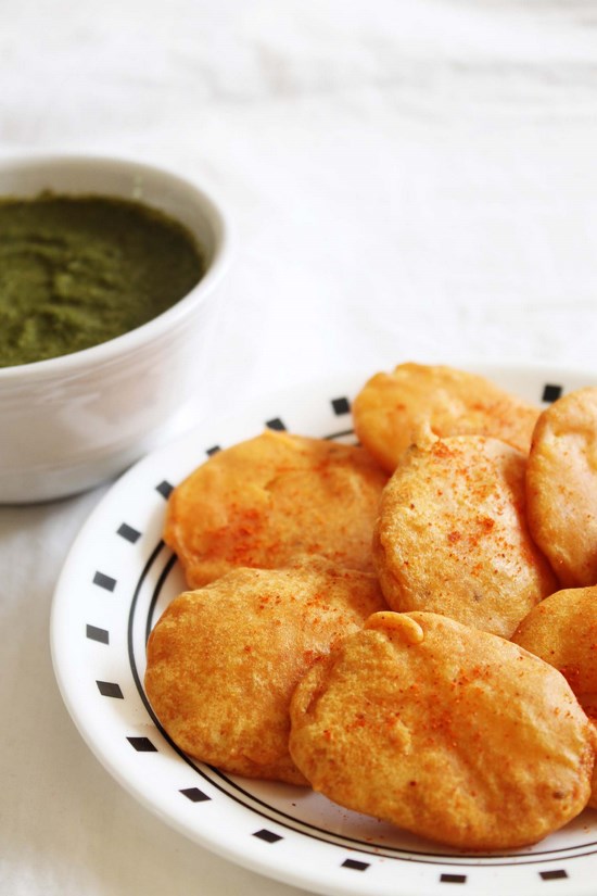 Aloo pakora in a plate with a bowl of chutney.
