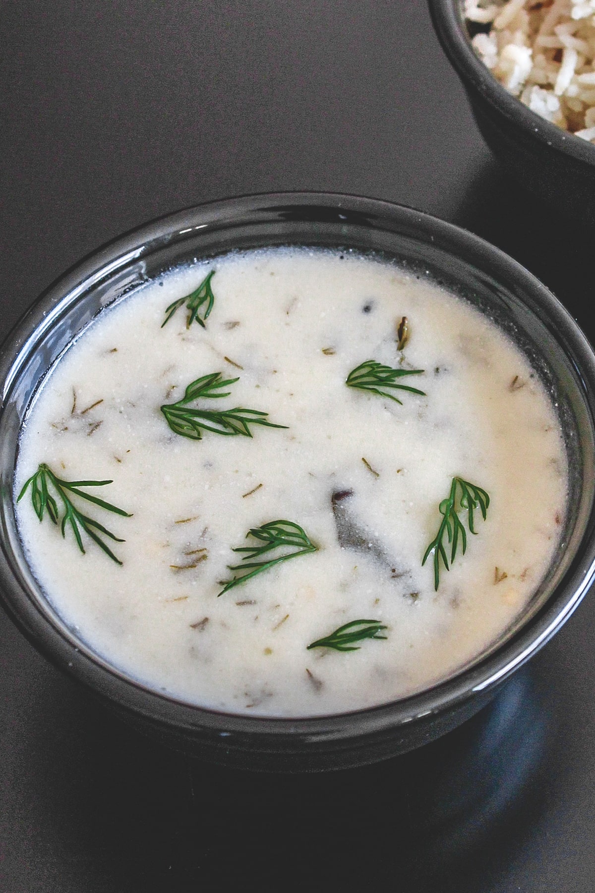 Dill leaves kadhi in a black bowl.