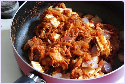 mixing paneer into the gravy