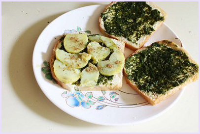 Placing potato slices and sprinkling sandwich masala.