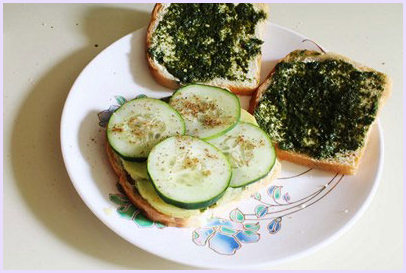 Placing cucumber slices and sprinkling sandwich masala.