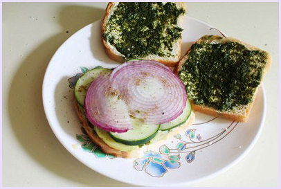 Placing onion slices and sprinkling sandwich masala.