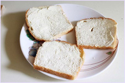 Spread butter on bread slice.