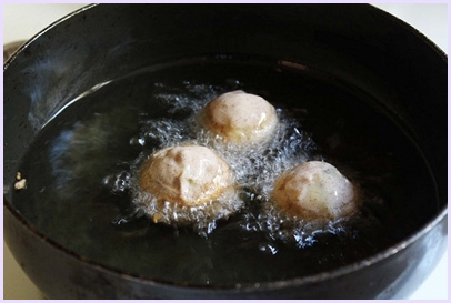 frying batata vada into hot oil