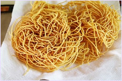 fried besan sev on paper-towel lined plate