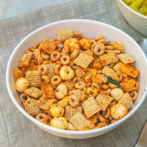 A bowl of cereal chivda with napkin under it.
