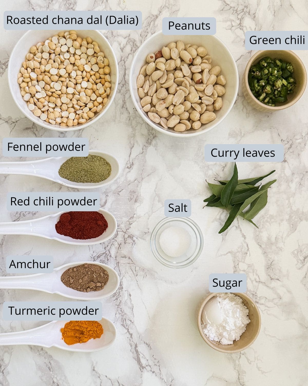 Cereal chivda ingredients in bowls and spoons with labels.