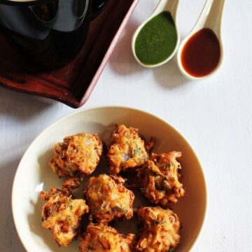 Cabbage pakoda served with chutneys and tea.