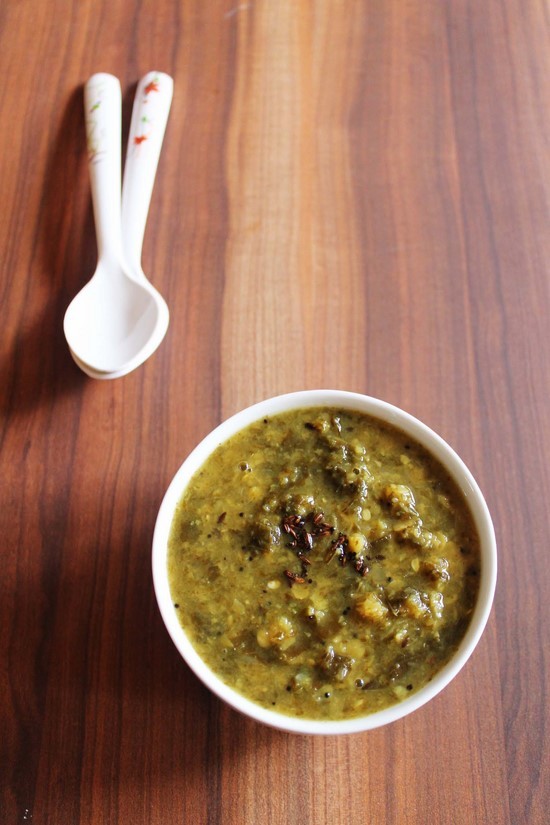 Gongura Pappu in a bowl with 2 spoons in the back.