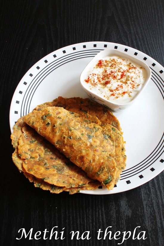 Methi thepla with a bowl of yogurt.