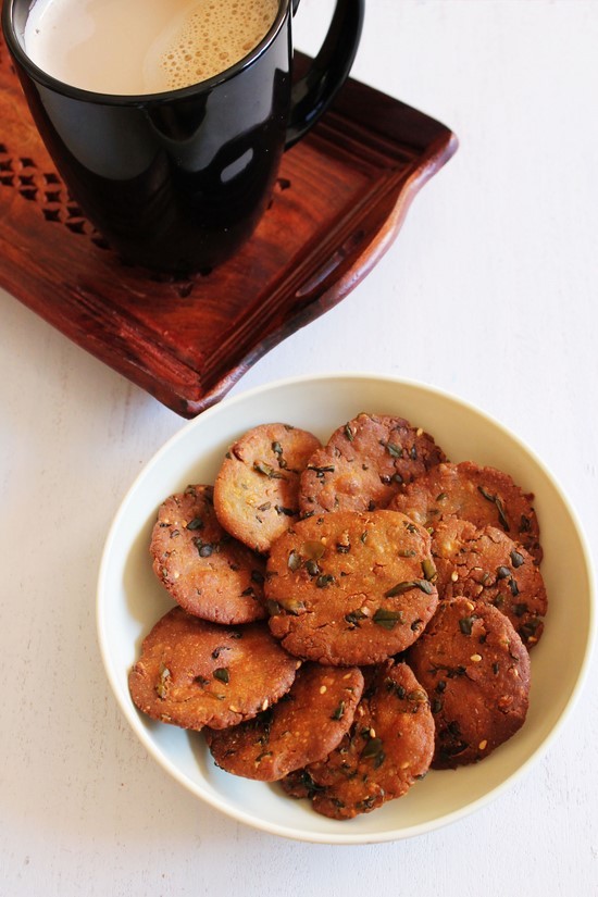 Bajri vada in a plate with a cup of coffee in a tray.