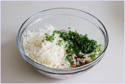 Adding cheese and cilantro in a bowl.