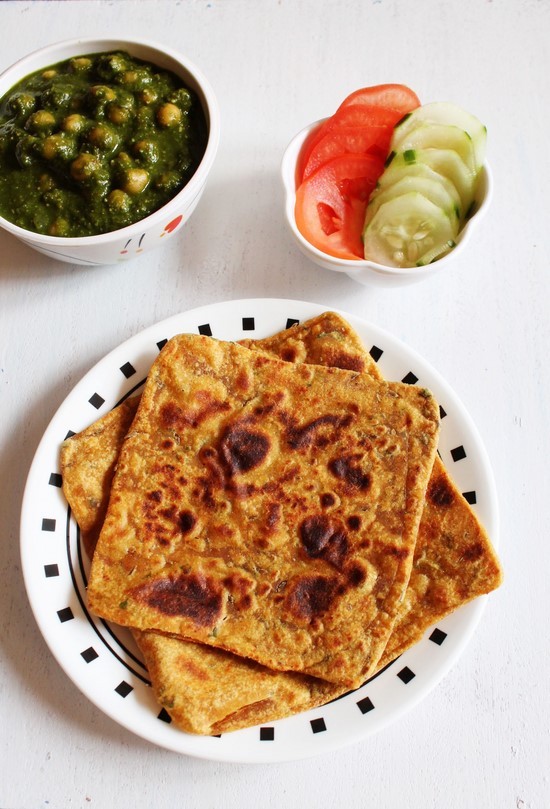 Masala Paratha with chole palak and cucumber, tomato slices.