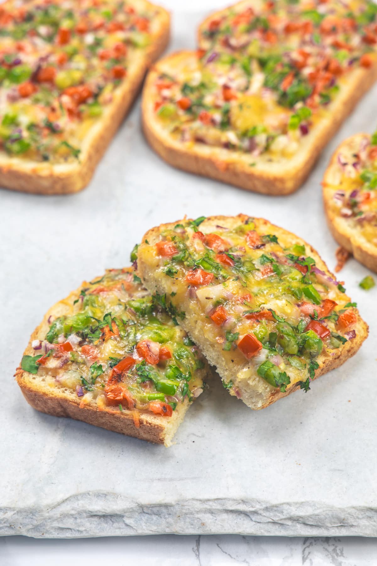 Slices of chilli cheese toast on a marble board.