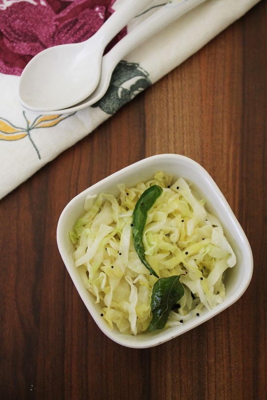 Cabbage Sambharo in a bowl with spoons in the back.