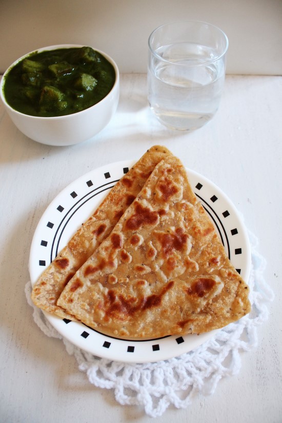 Ajwain Paratha with aloo palak and a glass of water.