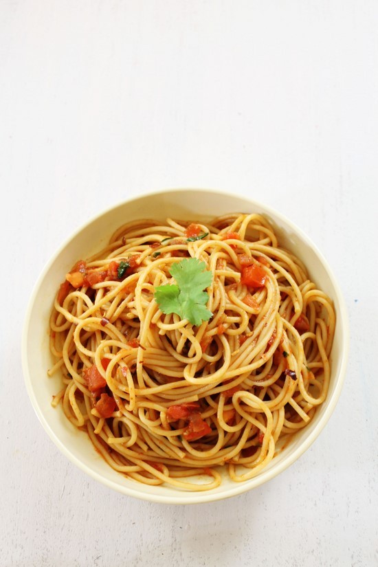 Spaghetti with Spicy Tomato Sauce served in a plate with a garnish of cilantro.