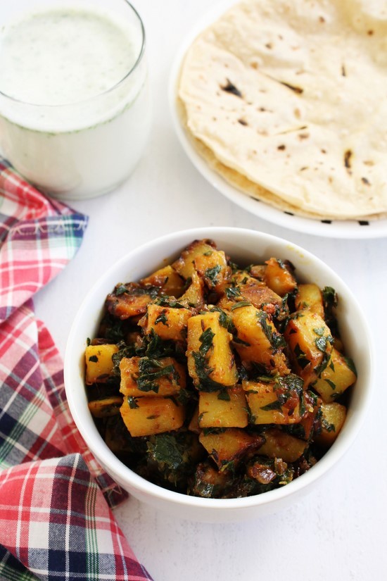 Aloo methi sabzi served with roti and a glass of chaas.