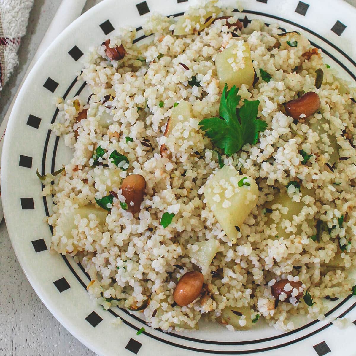 Samo khichdi in a plate garnished with a cilantro leaf.