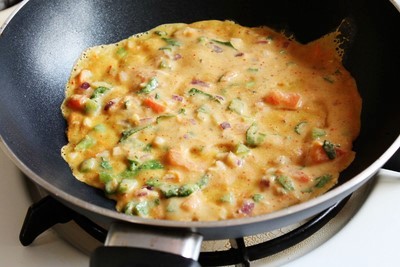 Cooking cheela in a pan.