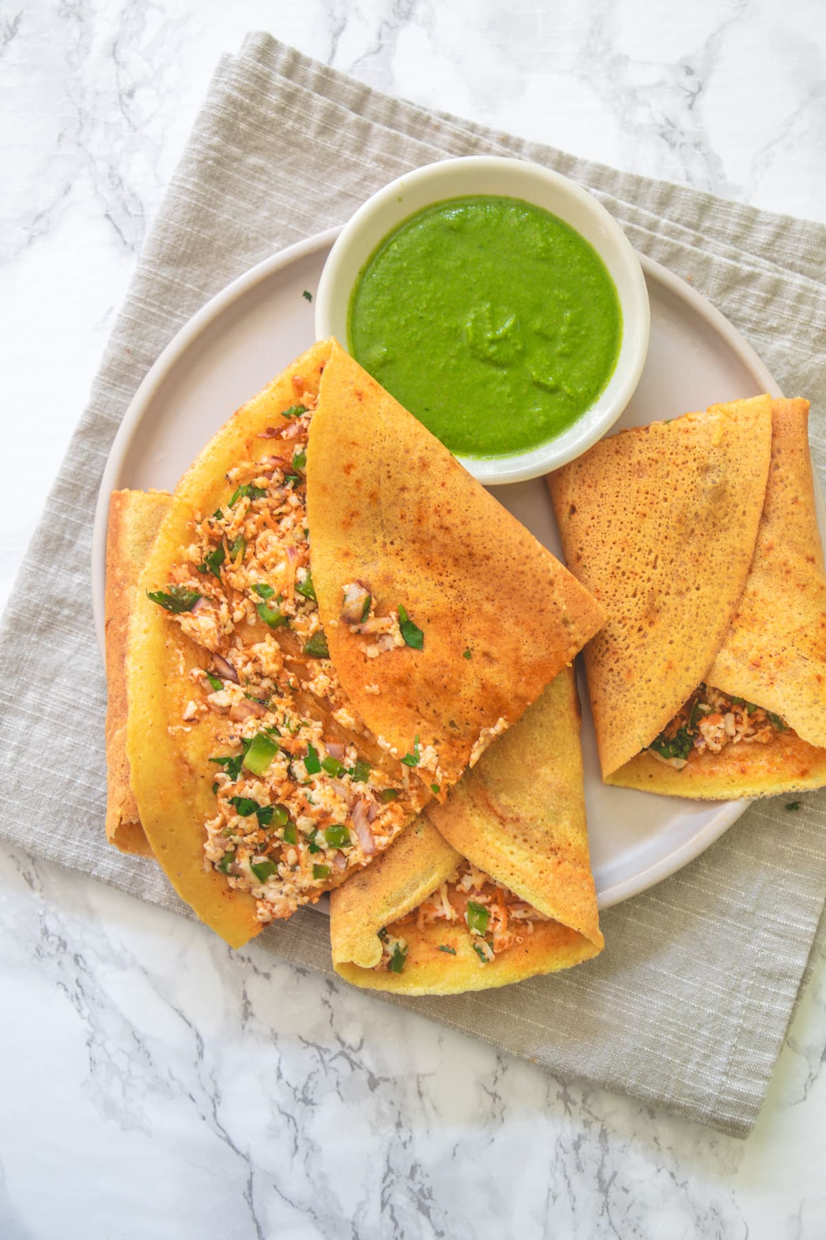 Opened up one piece of besan chilla to show the paneer stuffing inside.