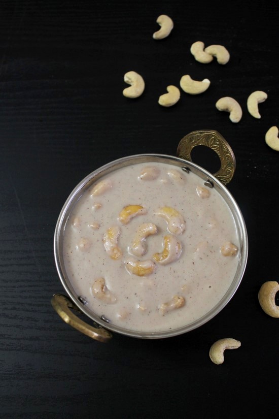 Khoya Kaju in a serving kadai with a few cashews on the side.