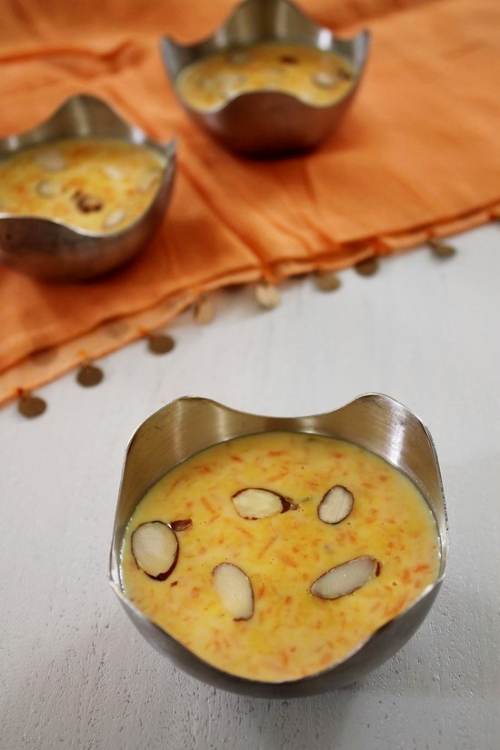  Carrot Payasam in a bowl garnished with almond slices. 