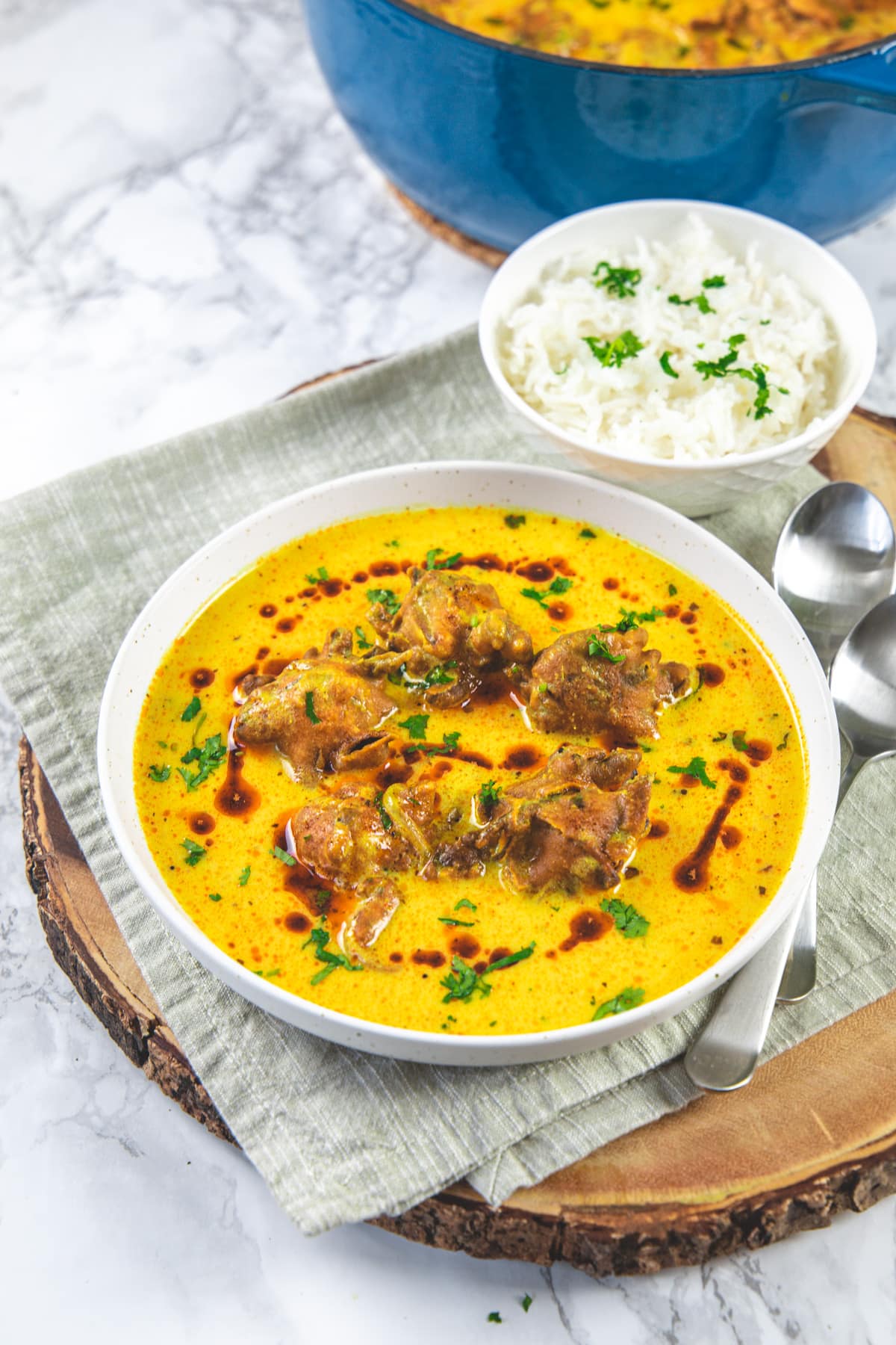 Kadhi pakora served with rice and 2 spoons on the side.