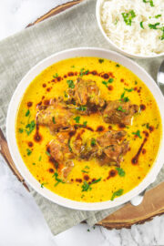 Punjabi kadhi pakora in a plate with a drizzle of ghee tadka and garnish of cilantro.