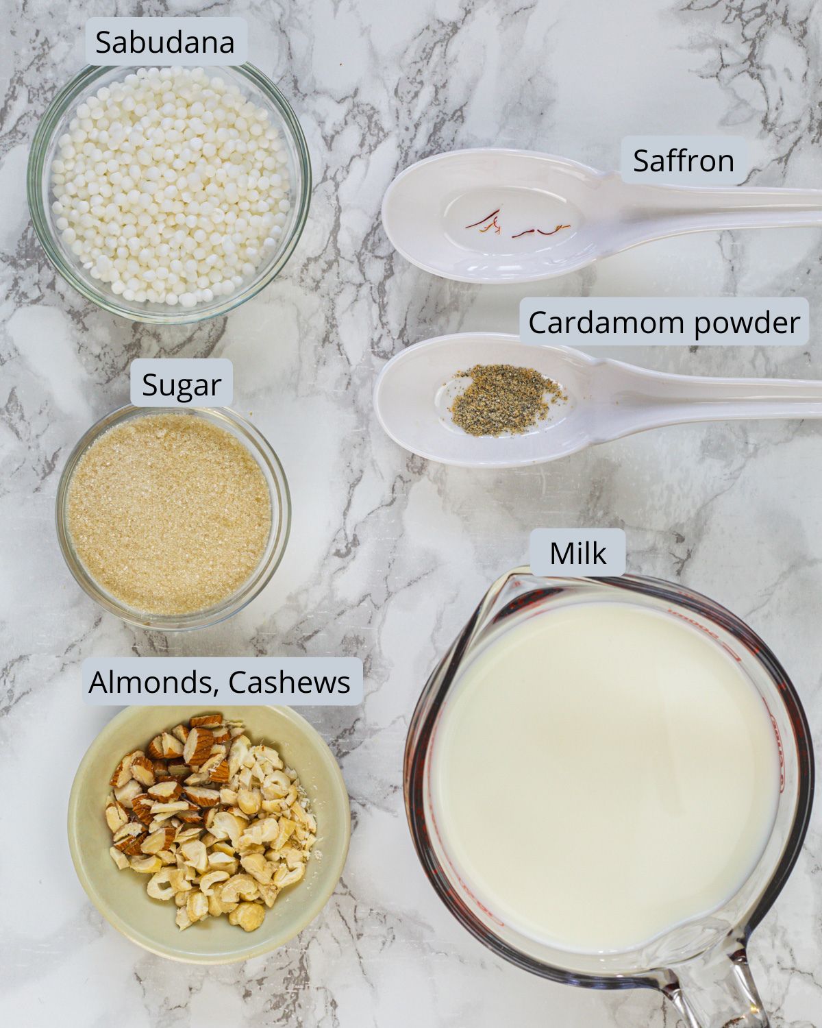 Sabudana kheer ingredients in bowls and spoons with labels.