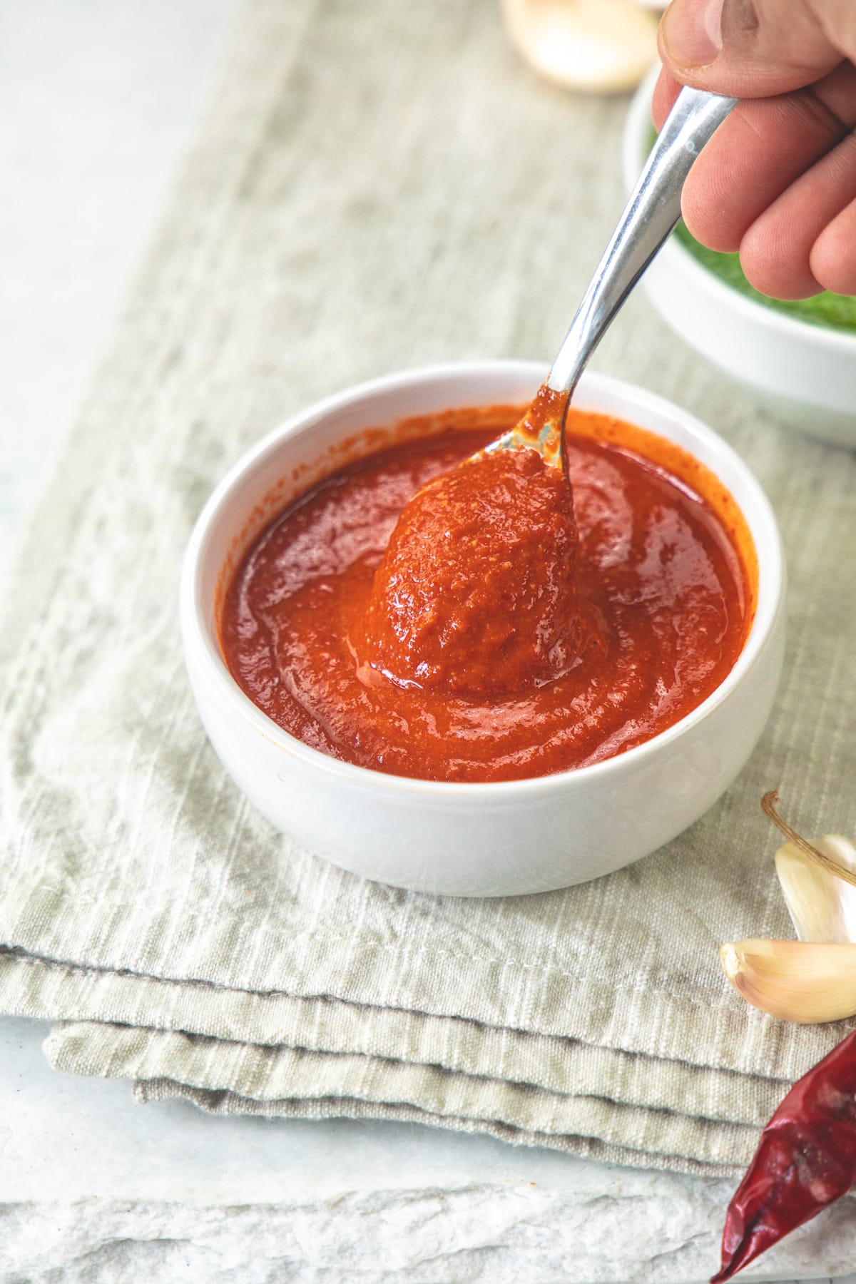 Taking spoonful of garlic chutney from the bowl.