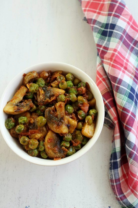 Matar mushroom sabzi in a bowl with napkin on the side.