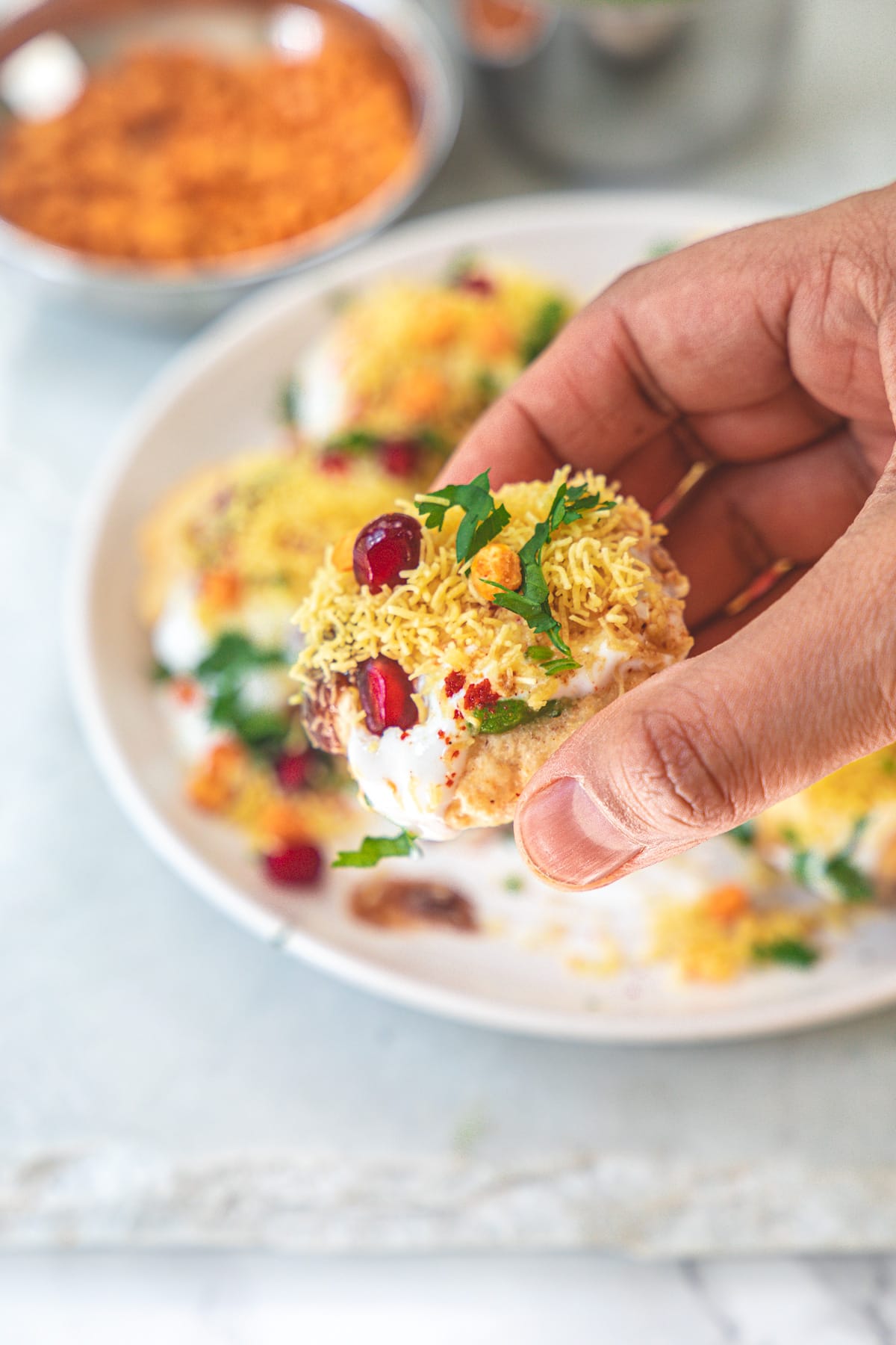 Taking one dahi puri chaat from the plate.