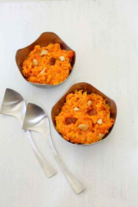 Gajar halwa with condensed milk in two bowls with 2 spoons on the side.